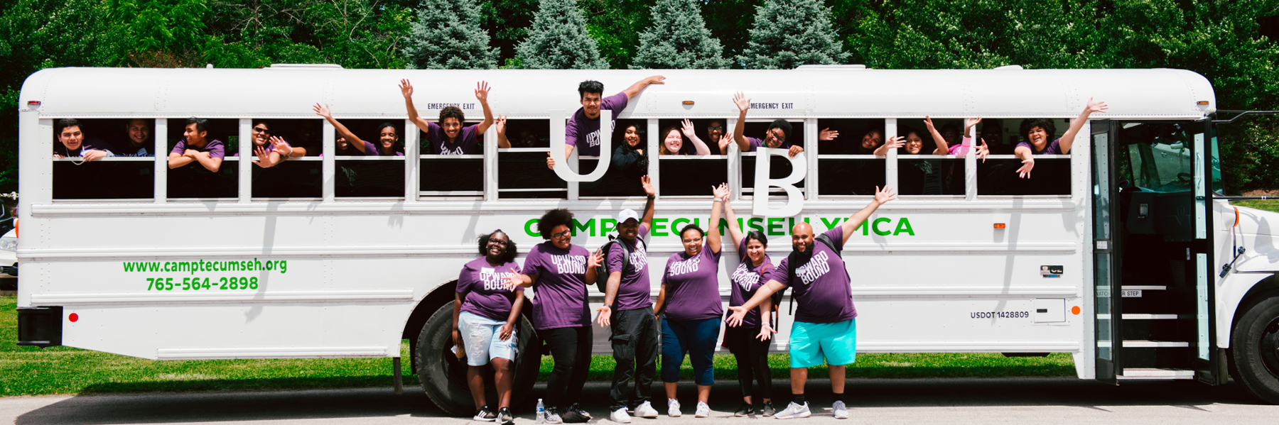 Upward Bound students smiling, raising their hands, and hanging out of a bus window holding the letters U and B.